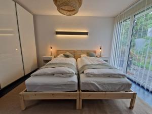 2 letti in una camera da letto con una grande finestra di Gästezimmer Gerlafingen a Gerlafingen