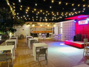 un palco con tavoli, sedie e luci di Attic Capsule Hotel a Marigondon