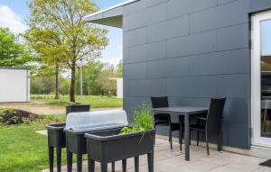 a patio with a table and chairs and a grill at Lovely Home In Ringkøbing With Kitchen in Ringkøbing +7 photos
