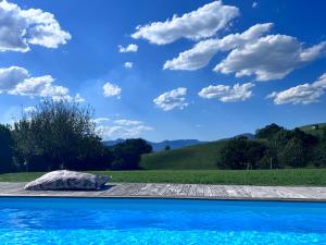 una piscina con cielo azul y nubes en Maison Biscaya , La chambre 2e étage, en Caro
