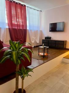 a living room with a red couch and a tv at Suite Bohémien Chic - A 5 Fermate dal Duomo in Milan
