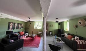 una sala de estar con paredes verdes y sofás en Maison Biscaya , La chambre 2e étage, en Caro