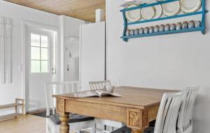 a dining room with a wooden table and white chairs at Awesome Home In Jægerspris With Wifi in Jægerspris