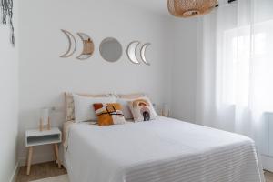 a white bedroom with a white bed with pillows at Wanderlust Estudio in Ribadeo