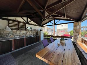 an outdoor kitchen and wooden table on a patio at Studios Fedra in Potamiá