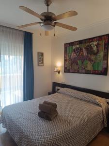 a bedroom with a bed with a ceiling fan at Bahía de Vera Apartamento Hibiscus in Vera