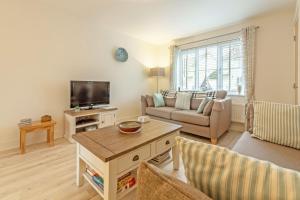 a living room with a couch and a tv at The Seahouse in Portreath