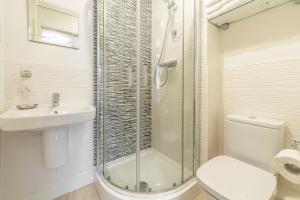 a bathroom with a shower and a toilet and a sink at The Seahouse in Portreath +16 photos