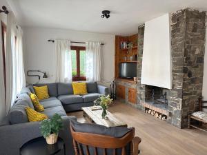 a living room with a couch and a fireplace at La Torre de la Vall de Camprodon in Llanars