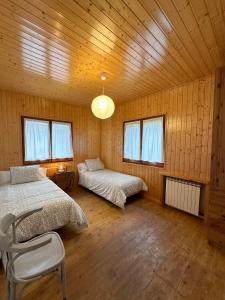 a bedroom with two beds in a room with wooden walls at La Torre de la Vall de Camprodon in Llanars