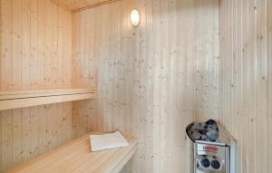 a inside of a sauna with a trash can at Lovely Home In Væggerløse With Sauna in Marielyst +23 photos