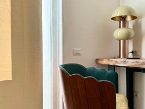 a chair sitting next to a table with a lamp at Anno13Suites in Naples