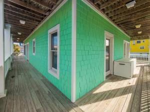 a green wall on a house with a deck at 1 Pleasure Island in Kure Beach +20 photos