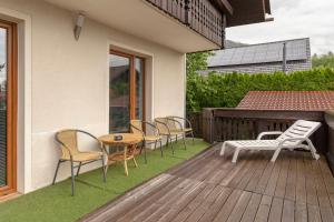 a deck with chairs and a table and a table and chairs at Apartmaji Seljak in Preddvor