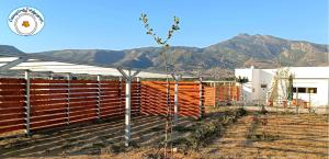 a fence in front of a building with mountains in the background at Camping.Karystos Melodia in Karistos