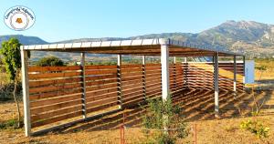 a wooden shed with a roof on a field at Camping.Karystos Melodia in Karistos