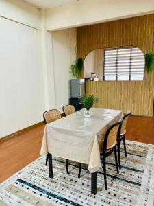 a dining room with a table and chairs on a rug at Selesa Homestay , Tingkat 1 di Bandar Jeli in Jeli
