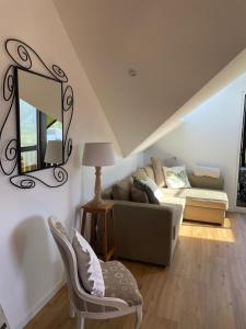 ein Wohnzimmer mit einer Couch und einem Spiegel in der Unterkunft Superbe T3 A DOUSSARD in Doussard + 3 Fotos