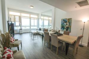 een woonkamer met een tafel, stoelen en een bank bij Castle PH15 Spacious Penthouse with Balcony, Beach Access, Pool, Tennis, Free Parking in Miami Beach