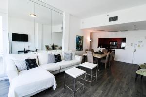 een woonkamer met witte meubels en een eetkamer bij Castle PH15 Spacious Penthouse with Balcony, Beach Access, Pool, Tennis, Free Parking in Miami Beach