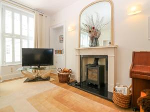 sala de estar con TV y chimenea en 1A Carmelite Street, en Banff