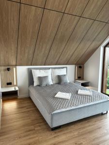 a bedroom with a large bed with a wooden ceiling at Domki pod Luboniem in Rabka