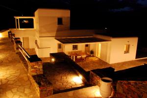 a house at night with a table and chairs at Seascape, Suite 3 with sea view in Áno Meriá