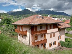 une maison sur une colline avec des montagnes en arrière-plan dans l'établissement CASA DOLOMIA - Cavalese Olimpiadi 2026, Dolomiti Affitti, à Cavalese