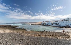 a group of people standing on a rocky beach at Casa Sebadal in La Santa