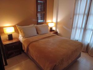 a bedroom with a large bed with two lamps at Alas Maisonette in Pefkohori