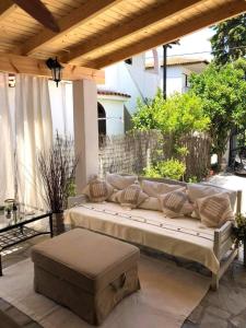 a large couch sitting under a pergola on a patio at Alas Maisonette in Pefkohori
