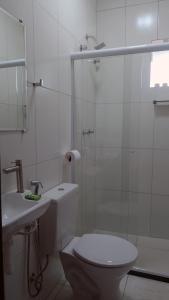 a bathroom with a toilet and a shower and a sink at FAROL BEACH Suítes in Salvador