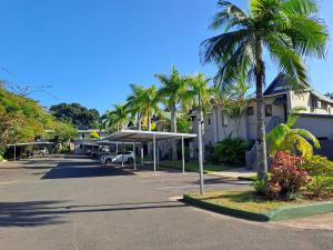 un aparcamiento con palmeras y un edificio en 52 The Bridge Apartment, en St Lucia