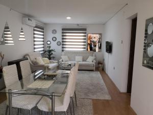 a living room with a couch and a table and chairs at Apartment Mirror in Visoko