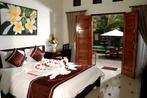 努沙杜瓦Kubu Garden Suites & Villas Nusa Dua的一间卧室，配有一张床和一扇通往露台的门