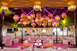 a room with pink chairs and tables and chandeliers at 555 Hotel Clubbing Adults Only in Marrakech +80 photos