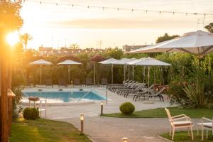 a pool with tables and chairs and umbrellas at Boutique Hotel Casa Mariantonia in Anacapri