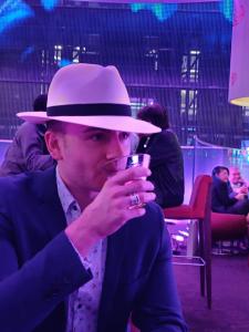 a man in a hat drinking a glass of wine at Auberge PVT Hostel in Montreal