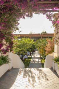 a garden with a pathway with flowers and trees at Boutique Hotel Casa Mariantonia in Anacapri