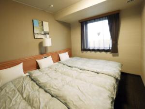 מיטה או מיטות בחדר ב-Hotel Route-Inn Yonezawa Ekihigashi