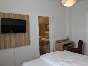 a bedroom with a bed and a bathroom with a sink at Gasthaus Mandelhof in Neustadt an der Weinstraße