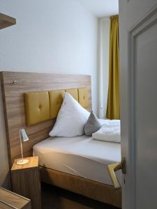 a bedroom with a bed with a yellow headboard at Gasthaus Mandelhof in Neustadt an der Weinstraße +29 photos