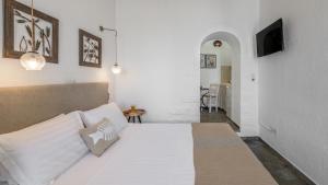 a bedroom with a large white bed and a hallway at Anastasia's Triovasalos in Triovasálos