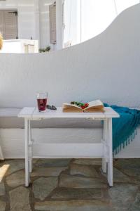 a white table with a book and a drink on it at Anastasia's Triovasalos in Triovasálos