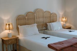 two beds in a room with two lamps on tables at Sentidos Beach Retreat in Miramar