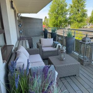 eine Terrasse mit Sofas und Stühlen auf einer Terrasse in der Unterkunft Nord House Apartament in Jastrzębia Góra