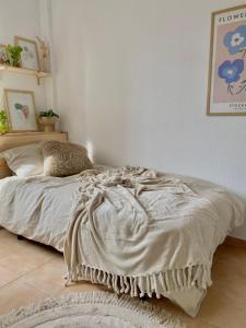ein Schlafzimmer mit einem Bett mit einer Decke darauf in der Unterkunft La Casita de Mamacita in Los Alcázares