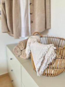 eine weiße Theke mit Handtüchern und einem Korb mit Handtüchern in der Unterkunft La Casita de Mamacita in Los Alcázares