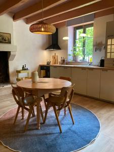 una cucina con tavolo e sedie in legno in una stanza di Encore une fois, La maison coloréé a Locmalo