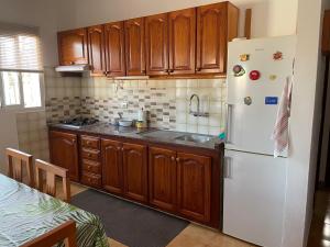 a kitchen with wooden cabinets and a white refrigerator at Casa Don Daniel in Arona